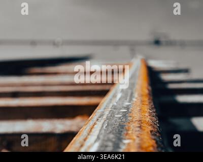 Close view of a single rusty railway track leading away at an industrial site on a sunny day Stock Photo