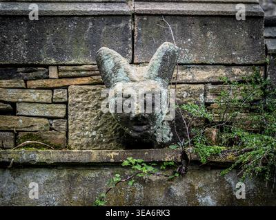 Carved stone grotesque above the doorway in the graveyard of St Michael’s Church, Hathersage, Derbyshire, England, UK Stock Photo