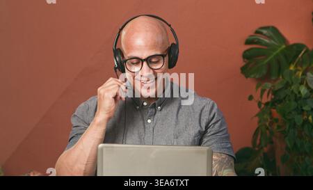Smiling Male Customer Service Representative On Video Call Wearing Headset In Modern Remote Office Stock Photo