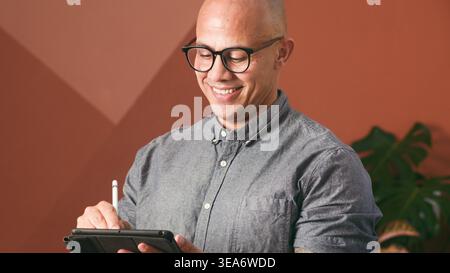 Smiling Businessman Using Tablet And Stylus In Modern Office Environment Stock Photo