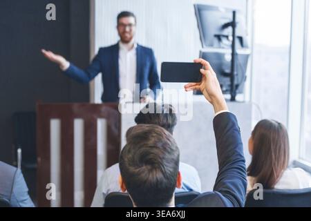 Entrepreneur recording lecture on smartphone camera, back view Stock Photo