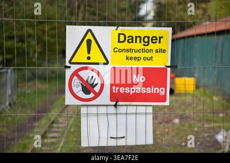 Construction Site Safety Warning Sign on Wire Perimeter Fence. Stock Photo