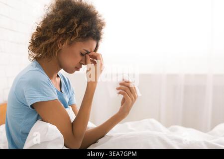 Young sick woman with flu blowing her nose Stock Photo
