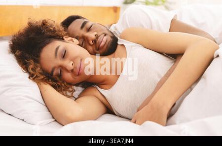 Couple Enjoying Time Together, Sharing a Moment of Rest in a Cozy Bed Stock Photo