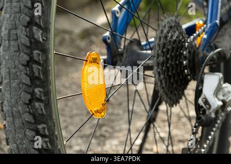 Orange spoke reflector on a bicycle wheel close up. Stock Photo
