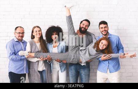 Joyful Multi-Ethnic Colleagues Having Fun, Posing Over White Brick Wall Background Stock Photo