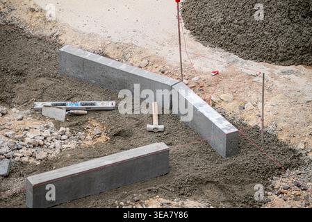 Spirit level and hammer on a concrete foundation The Concept of precision and engineering Stock Photo