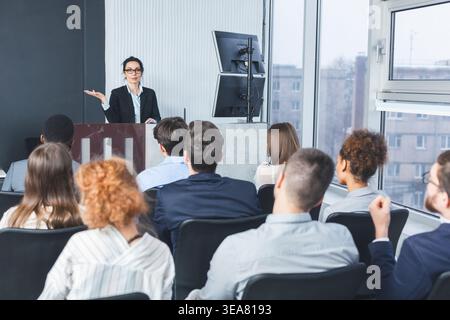 Business lecture. Coach giving presentation to young staff Stock Photo