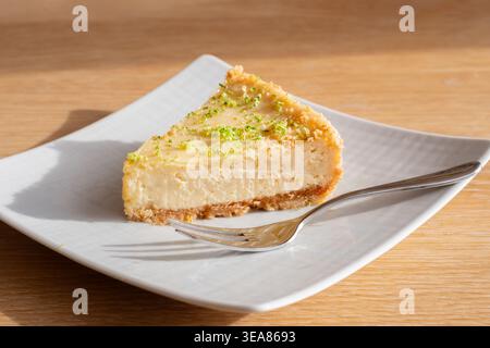 UK. A single slice or serving of key lime pie. A zesty citrus desert with a biscuit or graham cracker base. Stock Photo