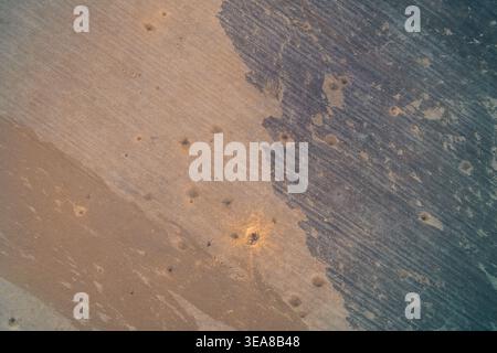 Abstract earth surface featuring contrasting shades of brown and grey soil. High angle drone view of agricultural land prepared for planting, creating a gritty industrial organic texture. Stock Photo