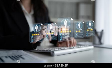 Businesswoman Analyzing Digital Employee Performance Metrics on Transparent Screen at Desk with Computer, Career Development, Professional Growth Stock Photo