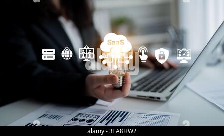 A business professional holds a glowing light bulb symbolizing innovation with SaaS icons. The scene captures modern work dynamics, blending Stock Photo