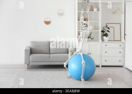 Human skeleton model on fitball in living room Stock Photo