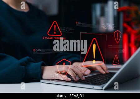 System Warning Alert for Cybersecurity Risk and Data Threat Concept. Woman using laptop with alert icons and system warning. data risk, cyber threat d Stock Photo