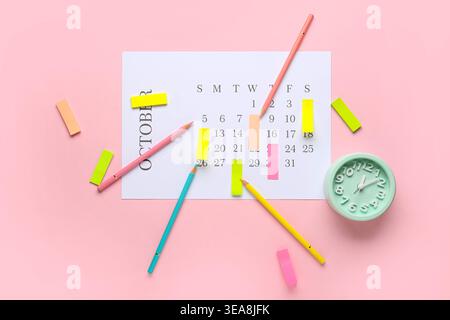 Calendar with alarm clock, pencils and sticky notes on pink background. Planning concept Stock Photo