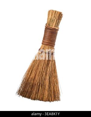 A small handmade rustic straw whisk broom isolated on white background. Traditional natural fiber tool that can be used for light cleaning or as decor Stock Photo