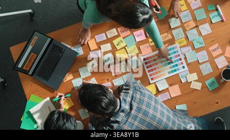 Group of creative team looking and planning idea while manager holding sticky notes and presenting marketing strategy to leader about startup project Stock Photo