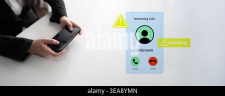 A close-up of a person holding a smartphone, with an incoming call from an unknown number, featuring a warning notification. Represents modern Stock Photo