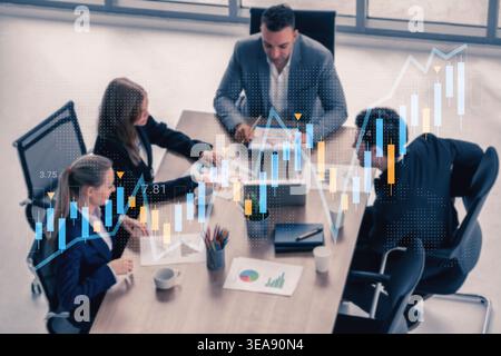 A diverse business team engaged in a strategic meeting, analyzing financial data and market trends using charts and digital tools in a modern Stock Photo
