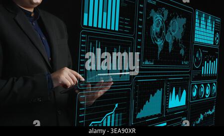 A professional business analyst interacts with a futuristic data visualization interface, exploring trends and insights to drive strategic decisions Stock Photo