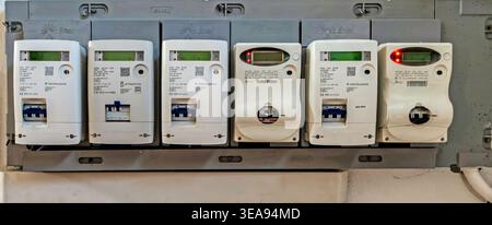 A row of Enel e-distribuzione digital electricity meters and circuit breakers installed in a building in Olbia, Sardinia, Italy. Stock Photo