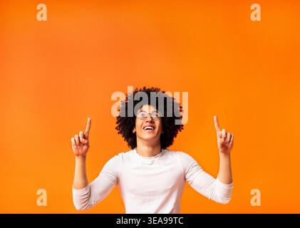Stylish black man in glasses pointing away at empty space Stock Photo