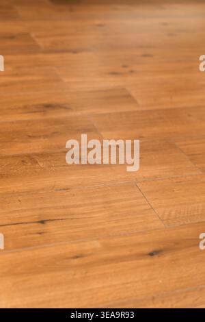 Light brown hardwood planks feature natural grain patterns. Smooth surface shows subtle knots and polished finish. Warm inviting texture suits modern Stock Photo