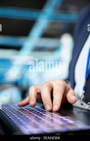 Typing on laptop, IT infrastructure and close up of programmer upgrading autonomous server room rigs. Writing on keyboard, notebook device and software developer updating server farm systems Stock Photo