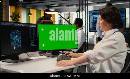 Isolated screen computer used by admin in office doing AI software development to launch new features. Chroma key PC used by worker in startup company writing artificial intelligence program, camera A Stock Photo