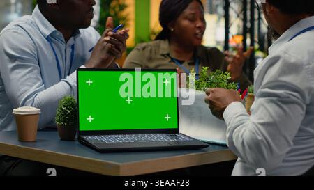 Green screen laptop used by tech startup office programmers doing meeting about neural network technology. Silicon Valley company shareholders using mockup notebook in conference room, camera B Stock Photo