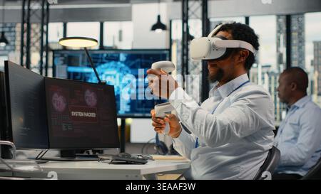 Programmer in office using virtual reality tech to fix hacking attempt on corporate network. IT expert uses VR headset to investigate unauthorized access alerts, working to mitigate damages, camera B Stock Photo