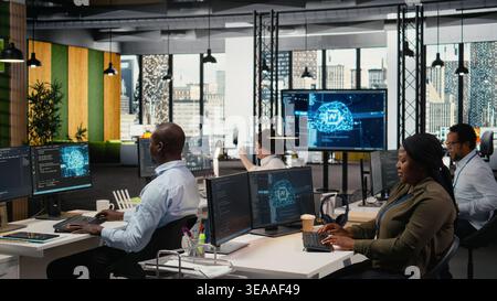 System administrators in startup office work with artificial intelligence driving market innovation. Tech agency IT specialists brainstorming to apply deep learning optimizing operations, camera A Stock Photo