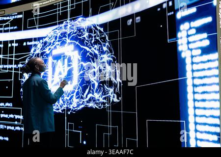 Autonomous AI agent writing complex code under female programmer supervision. African american woman tracking self generating architecture of advanced artificial intelligence model Stock Photo