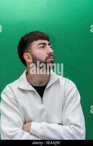 Young man contemplating looking up green screen Stock Photo