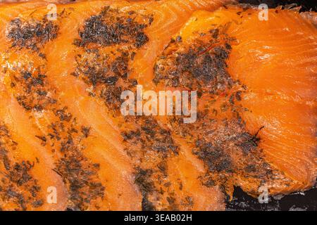 Salmon fillets are grilled and seasoned with spices. They are laid out on a plate at a cooking event during the afternoon. The colors are vivid, and t Stock Photo