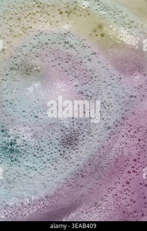 Colorful foam and bubbles produced by bath bombs in water, creates an organic, textured background element resembling a nebula scene from outer space. Stock Photo