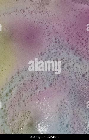 Colorful foam and bubbles produced by bath bombs in water, creates an organic, textured background element resembling a nebula scene from outer space. Stock Photo