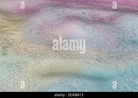 Colorful foam and bubbles produced by bath bombs in water, creates an organic, textured background element resembling a nebula scene from outer space. Stock Photo