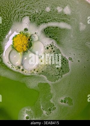 Colorful foam and bubbles produced by bath bombs in water, creates an organic, textured background element resembling a nebula scene from outer space. Stock Photo