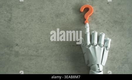 Top view of a white mechanical hand interacting with an orange question mark on a gray surface. Stock Photo