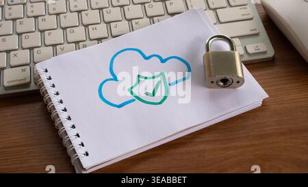 A drawing of a blue cloud with a green shield and checkmark on a notebook, placed next to a metal padlock and computer keyboard. Stock Photo