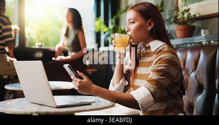 Woman, phone and drink in cafe for remote work, trend research and conversation. Freelance person, laptop and texting in coffee shop for project Stock Photo