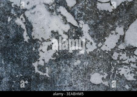 A top-down view of a heavily weathered concrete wall displaying a gritty grunge texture. Stock Photo