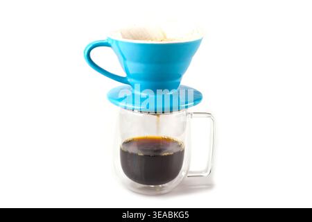Professional manual drip coffee brewing with blue ceramic V60 dripper. Pouring hot water over coffee on white background. Stock Photo