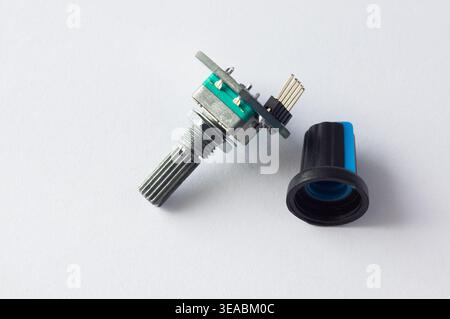 Close-up of a rotary potentiometer with a removed black control knob on a white background, showing an electronic component used for analog signal adj Stock Photo