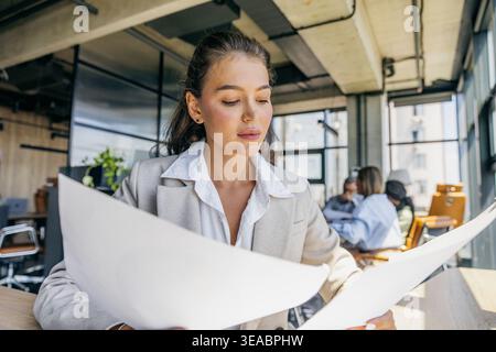 Architectess Intensely Studies Large Scale Blueprints In Collaborative Creative Environment Stock Photo