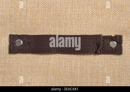 Brown fabric handle on beige canvas background closeup Stock Photo