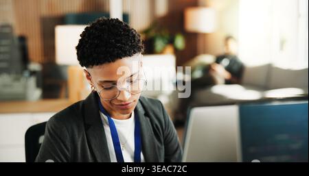 Woman, computer and review with smile at office for software development, notes and insight at tech company. Person, programmer and happy with glasses Stock Photo