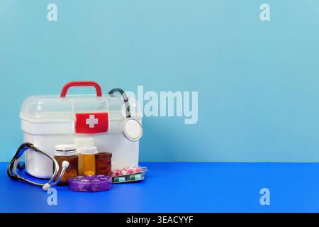 First aid kit with medical supplies and stethoscope on blue background Stock Photo