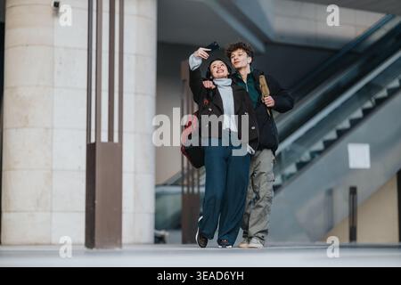 High school friends taking a selfie together while walking through a modern public building Stock Photo